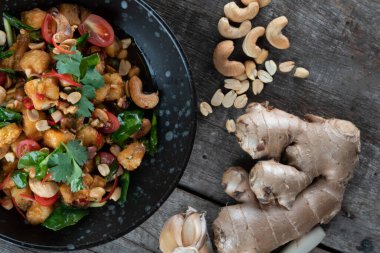 Gai Pad Med Mamuang veya Tayland kaju tavuğu ahşap kırsal masada siyah kasede.