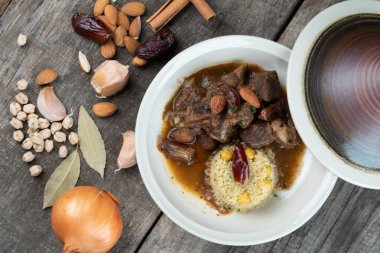 Ağır ateşte pişmiş kuzu, patates ve ahşap masada sıcak kuskus ve nohut ile servis edilen hurmalar.