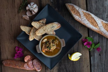 Gambas Pil Pil 'in üst manzarası - Çili biberli ve sarımsaklı karidesler ahşap kırsal masada izole edilmiş ekmekle servis ediliyor