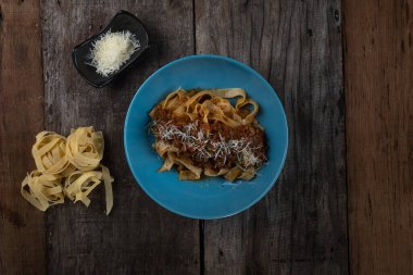 Tahta masaya izole edilmiş fettuccini makarnalı baharatlı makarna manzarası.