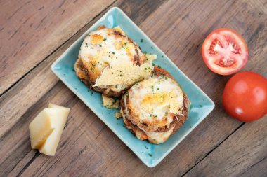 Tavada kızarmış patlıcan ve parmesan peyniri kabuğu ahşap masada izole.