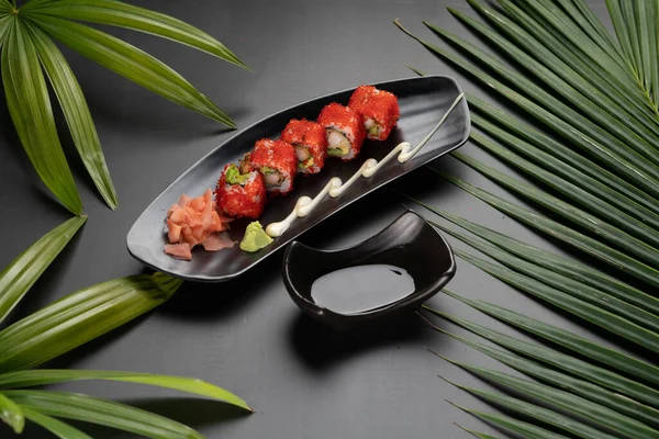 Sült Garnélarák Avokádó Majonéz Tobiko Sushi Fekete Asztalon Trópusi Levelekkel — Stock Fotó