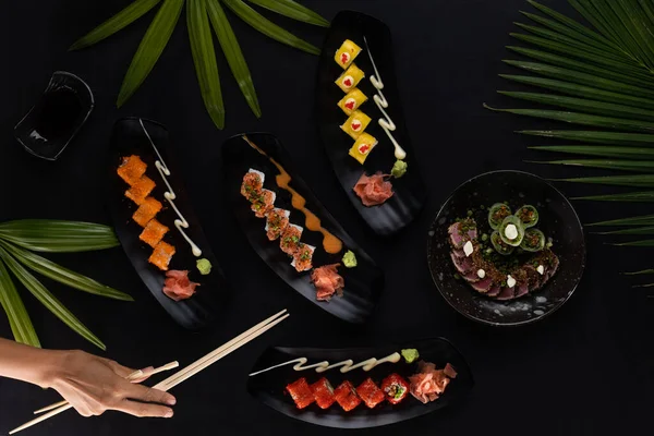 Top View Kéz Evőpálcikával Keveréke Sushi Japán Étel Felett Fekete — Stock Fotó