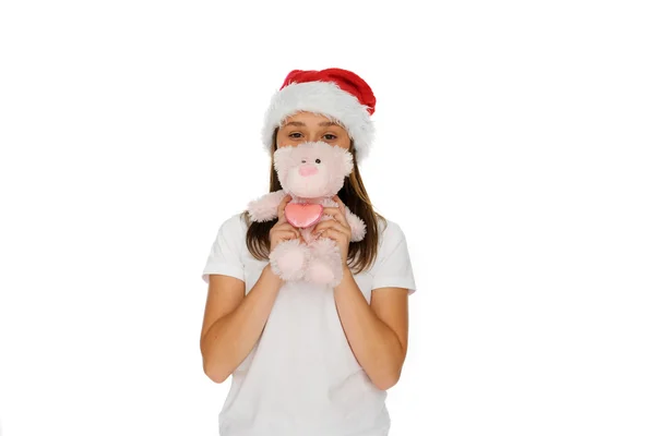 Young girl in a Santa hat with a teddy bear — Stock Photo, Image