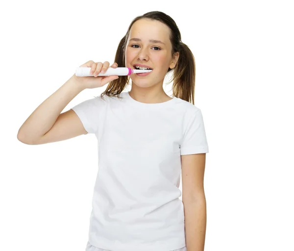 Girl brushing her teeth with an electric brush — Stock Photo, Image