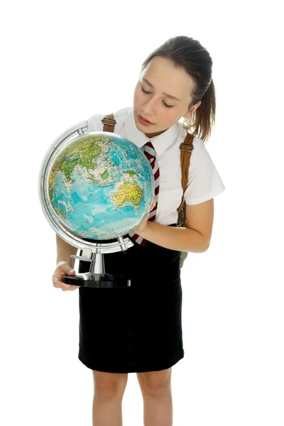 Joven colegiala examinando un mundo globo — Foto de Stock