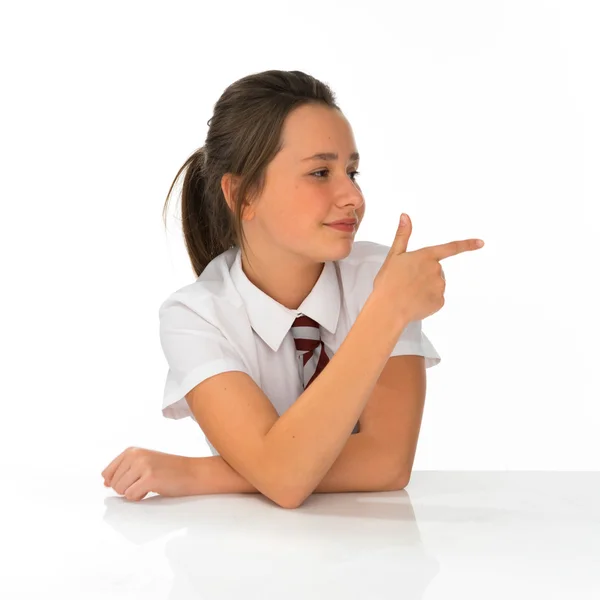 Young schoolgirl pointing to the right of the frame — Zdjęcie stockowe