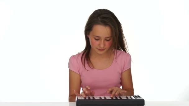 Chica joven tocando música en un teclado pequeño — Vídeo de stock