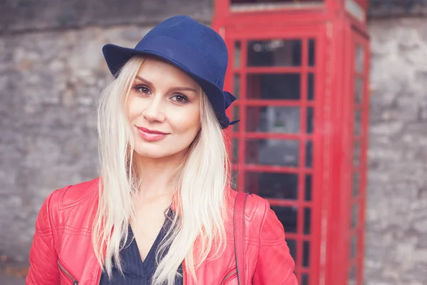 Lachende blonde vrouw in een rood lederen jas — Stockfoto