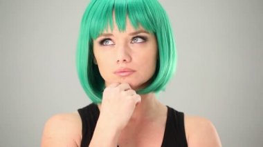 Düşünceli kadın yeşil peruk takmış