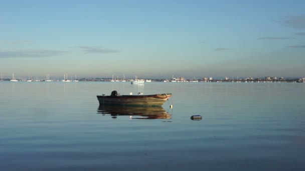 Empty fishing boat floating on a calm sea — Stock Video