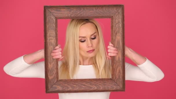 Verleidelijke vrouw uitwerking van haar gezicht in een frame — Stockvideo