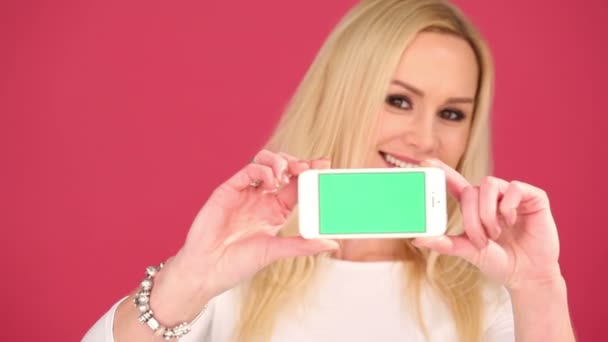 Attractive woman displaying a blank mobile phone — Stock Video