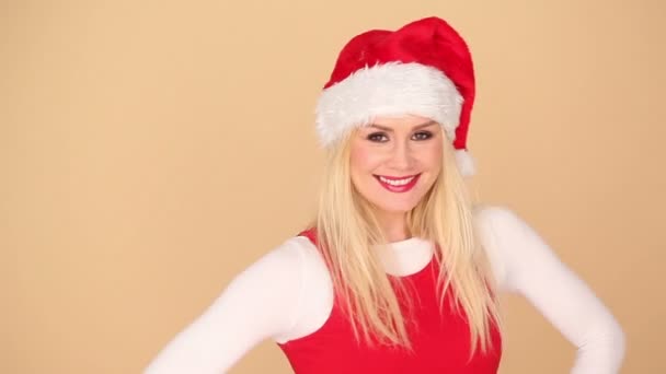 Schattige blonde meisje in een feestelijke rode kerstmuts — Stockvideo