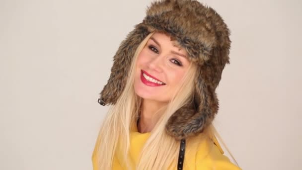 Hübsche Frau in gelber Mode mit pelziger Kapuze — Stockvideo