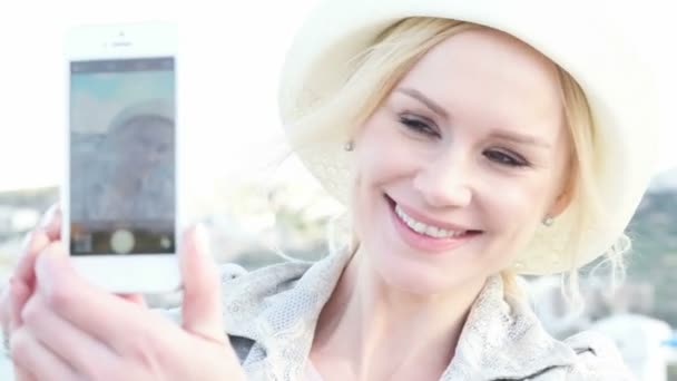 Γυναίκα λήψη αυτοπροσωπογραφία σε εξωτερικούς χώρους μοιράζονται φωτογραφίες κοινωνικών μέσων μαζικής ενημέρωσης από τις διακοπές που φοράει καπέλο — Αρχείο Βίντεο