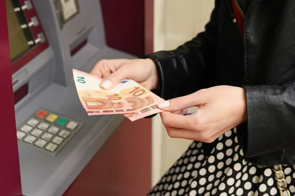 Vrouw met ingetrokken geld uit de Geldautomaat — Stockfoto