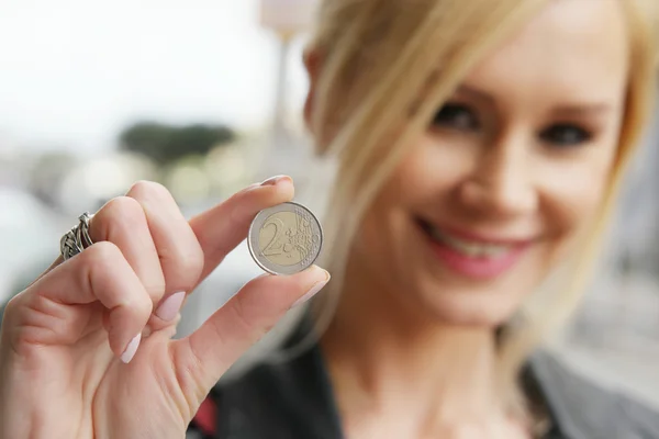 Mujer mostrando una moneda en la cámara — Foto de Stock