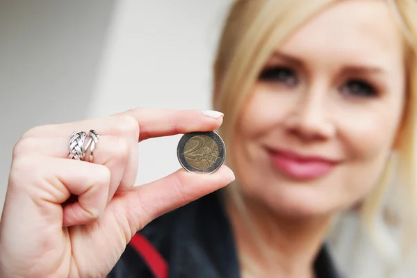 Mujer mostrando una moneda en la cámara — Foto de Stock