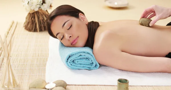 Bella donna godendo di un massaggio di pietra lavica — Foto Stock