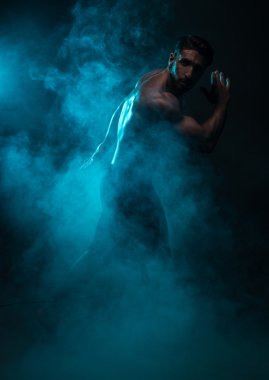 Silhouette Shirtless Muscled Man Posing in Smoke clipart