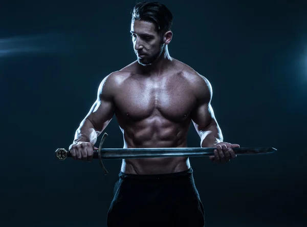 Magnifique homme musclé sans chemise tenant une épée — Photo