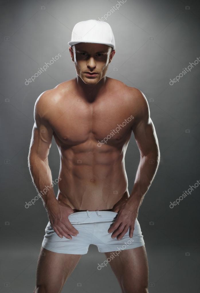 Athletic Young Man in Sexy Gym Shorts and a Cap Stock Photo by