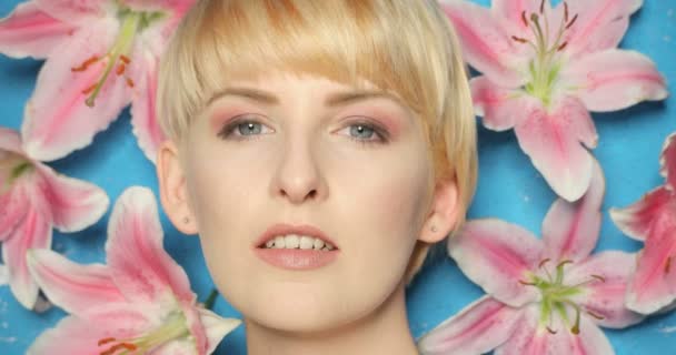 Skönhet kvinna på blå bakgrund med blomma — Stockvideo