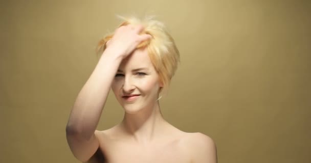 Коротковолосая блондинка трогает волосы — стоковое видео
