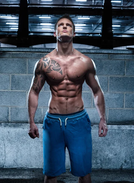 Красивий атлетичний молодий чоловік з татуюванням Дивлячись вгору — стокове фото