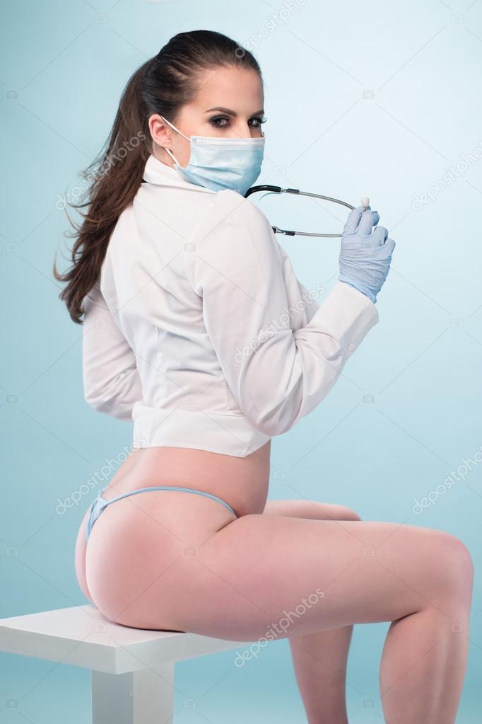 Sexy Nurse in Shirt and Panties Sitting on a Stool Stock Photo by