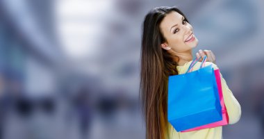 Happy female shopper carrying her purchases clipart