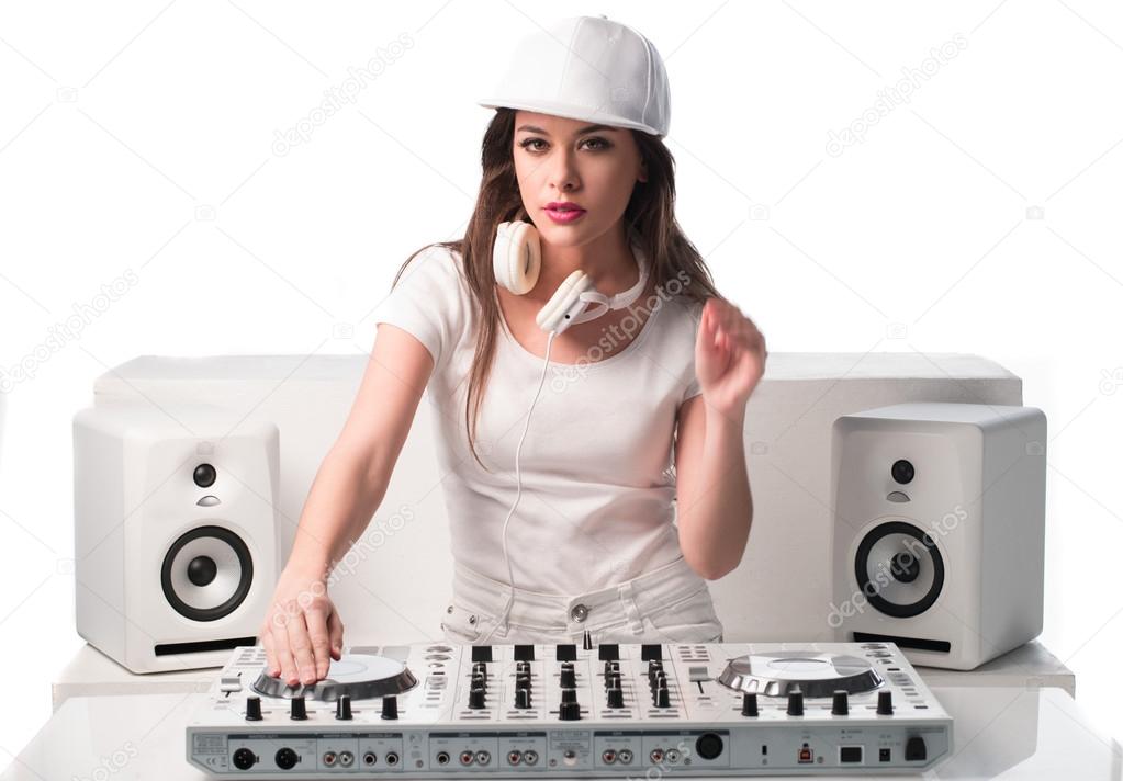 Trendy sexy DJ dressed in white mixing music