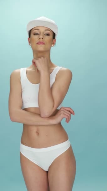 Jovem mulher atraente posando em roupa interior branca e um tampão — Vídeo de Stock