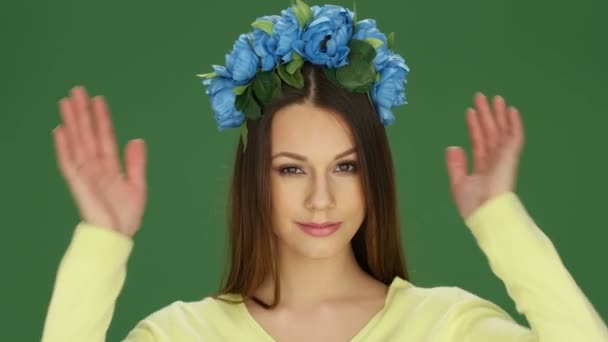 青い花の頭飾りを身に着けている魅力的な若い女性 — ストック動画