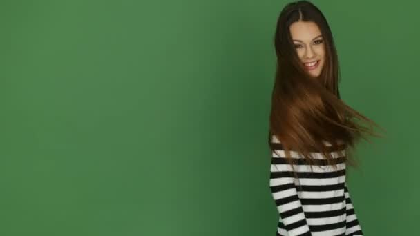 Gelukkig Brunette Model dragen gestreept boven op groene achtergrond — Stockvideo