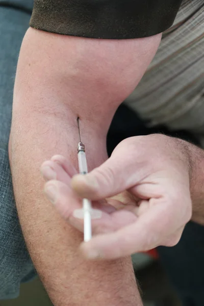 Hombre inyectándose a sí mismo con una pequeña hipodérmica — Foto de Stock