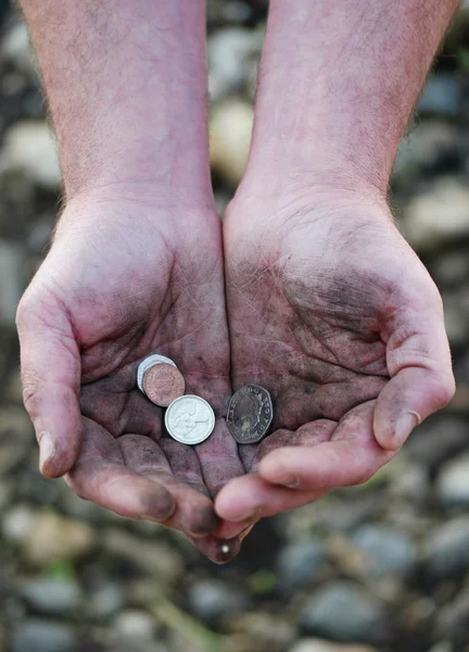 Smutsiga kupade händer som håller några mynt — Stockfoto