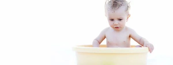Baby Sitting in a Yellow Bath Basin Against White — Stock Photo, Image