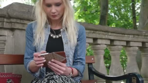 Attractive blonde texting sitting on the bench — Stock Video