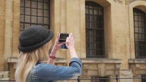 Приваблива блондинка бізнес-леді, використовуючи смартфон, щоб сфотографуватися у відпустці — стокове відео