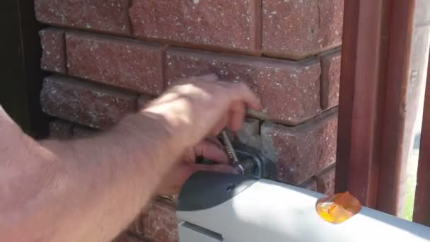 Man working on setting up gate door using screw driver — Stock Video