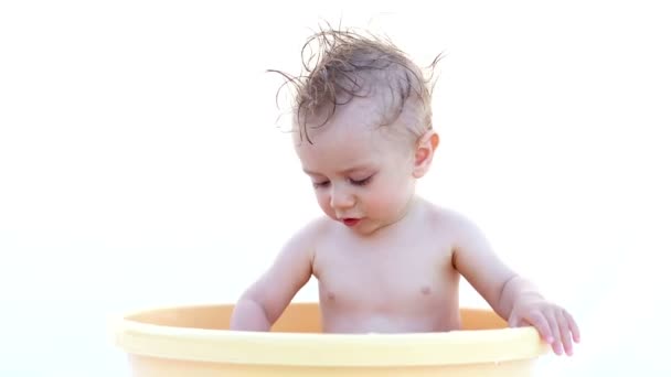 Kleine gelukkige baby. Kind spelen in de kom met water — Stockvideo