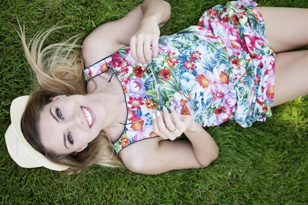 Sorridente bella giovane donna sdraiata sull'erba — Foto Stock