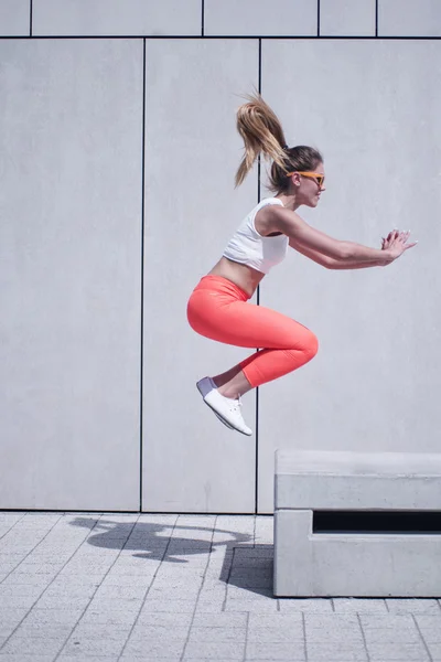 Active Woman Jumping Midair Onto Bench — Zdjęcie stockowe
