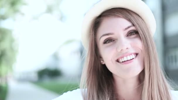 Portrait d'une jolie femme gaie portant un chapeau par temps chaud ensoleillé. Promenade au parc d'été et étudiant souriant — Video