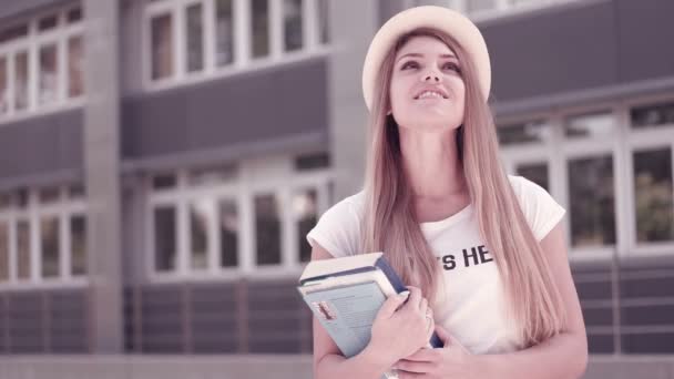 Kitap tutan gülümseyen üniversiteli kız Portresi — Stok video