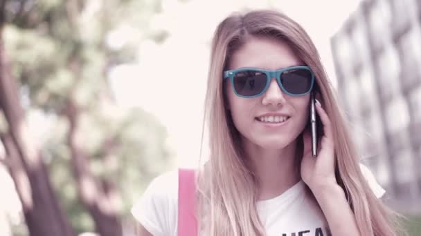 Приваблива щаслива студентка, яка розмовляє по мобільному телефону — стокове відео