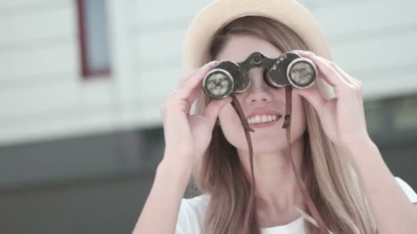 Aantrekkelijke lachende vrouw met een verrekijker — Stockvideo
