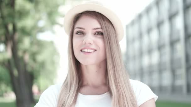 Retrato de una mujer bastante alegre con sombrero en un día soleado de clima cálido. Caminando en el parque de verano y estudiante sonriente — Vídeo de stock